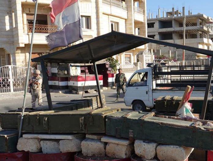 Des soldats syriens stationnnés à un poste de contrôle dans un quartier de Deraa, dans le sud-ouest de la Syrie.