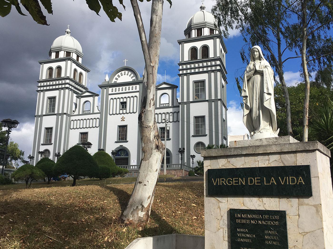 A statue of the Virgin Mary on the grounds of the Catholic Basilica of Our Lady of Suyapa in Tegucigalpa, Honduras. The statue is labeled “Virgin of Life” with a plaque by an anti-abortion group called Comite Provida (Pro Life Committee) commemorating “th