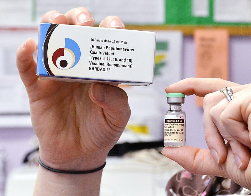 A child health nurse holds up a vial and box for the HPV vaccine, brand name Gardasil
