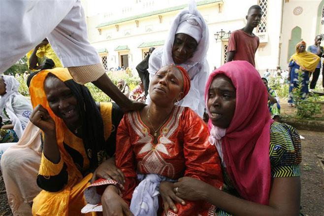 Le 2 octobre 2009 devant la grande mosquée Fayçal à Conakry, la capitale guinéenne, des membres d’une famille pleurent en identifiant le corps d’un proche tué quelques jours auparavant, le 28 septembre 2009, lorsque les forces de sécurité ont ouvert le fe