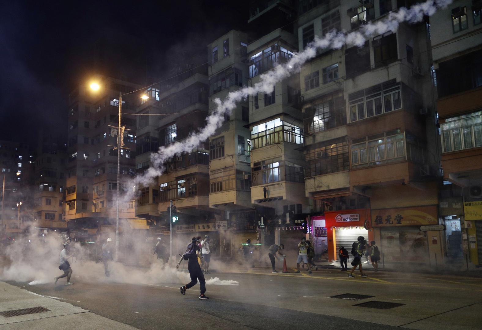 Protesters react to teargas from the Sham Shui Po police station in Hong Kong, August 14, 2019.