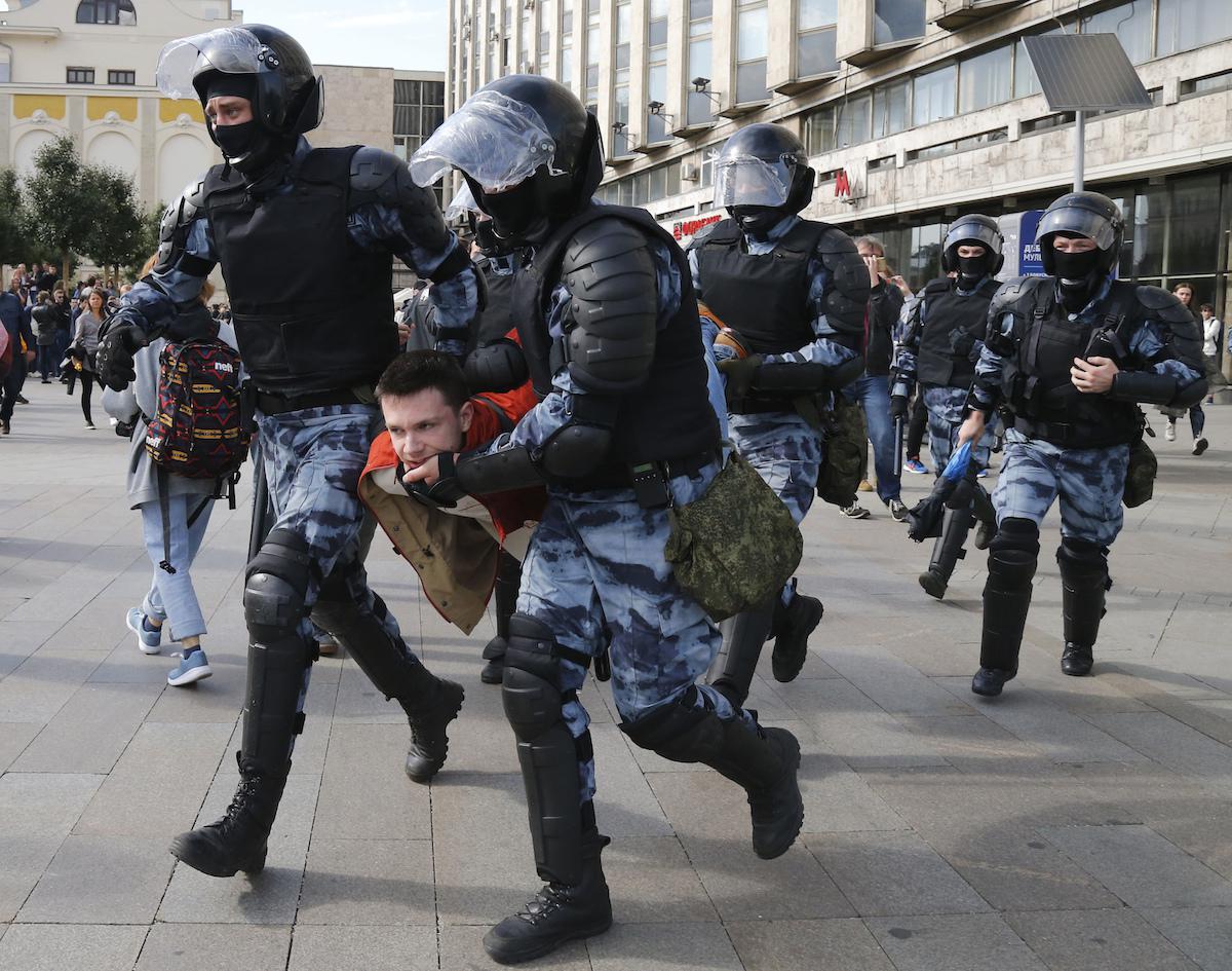 Police officers detain a protestor, during a peaceful protest in the center of Moscow, Russia, Saturday, Aug. 3, 2019.