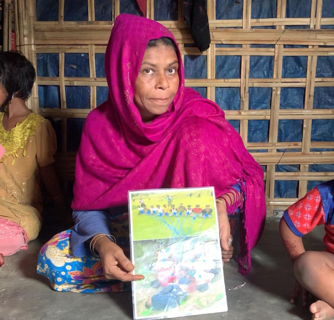Rahama Khatun holds up photos of her husband who was massacred in Myanmar’s Inn Din village on September 2, 2017, in Cox’s Bazar refugee camp, Bangladesh, August 14, 2019.