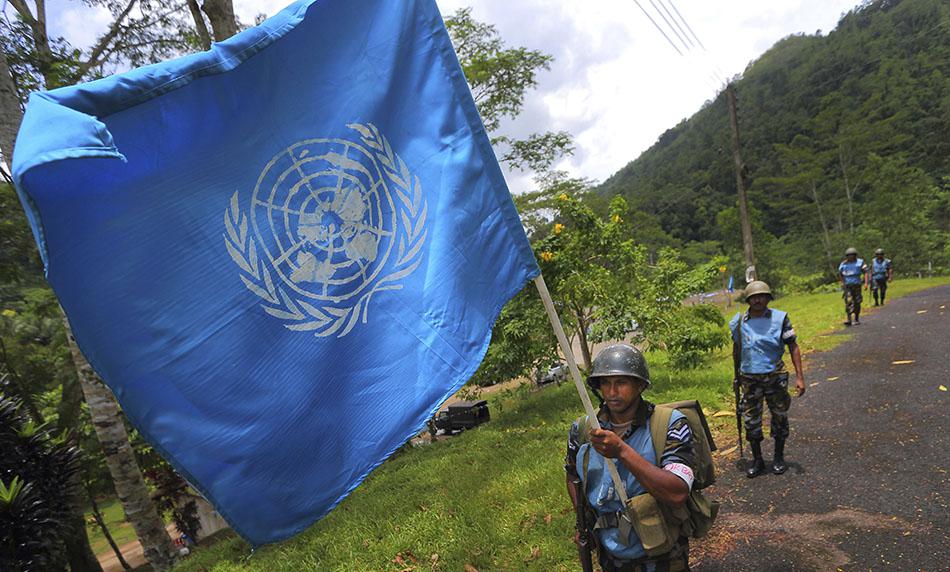 A Sri Lanka Air Force airman carries the UN flag during training for a road patrol at the Institute of Peace Support Operations Training in Kukuleganga, Sri Lanka.