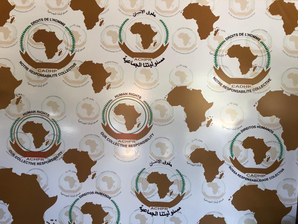 Bannière de la Commission africaine des droits de l’homme et des peuples, visible lors de la 65ème session ordinaire de la CADHP à Banjul, en Gambie, en octobre 2019. On peut y lire la devise « notre responsabilité collective » dans les quatre langues de 
