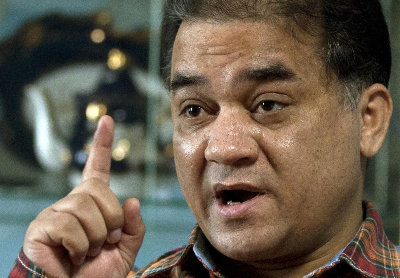 In this Feb. 4, 2013 file photo, Ilham Tohti, an outspoken scholar of China's Uighur minority, gestures as he speaks during an interview at his home in Beijing, China. 