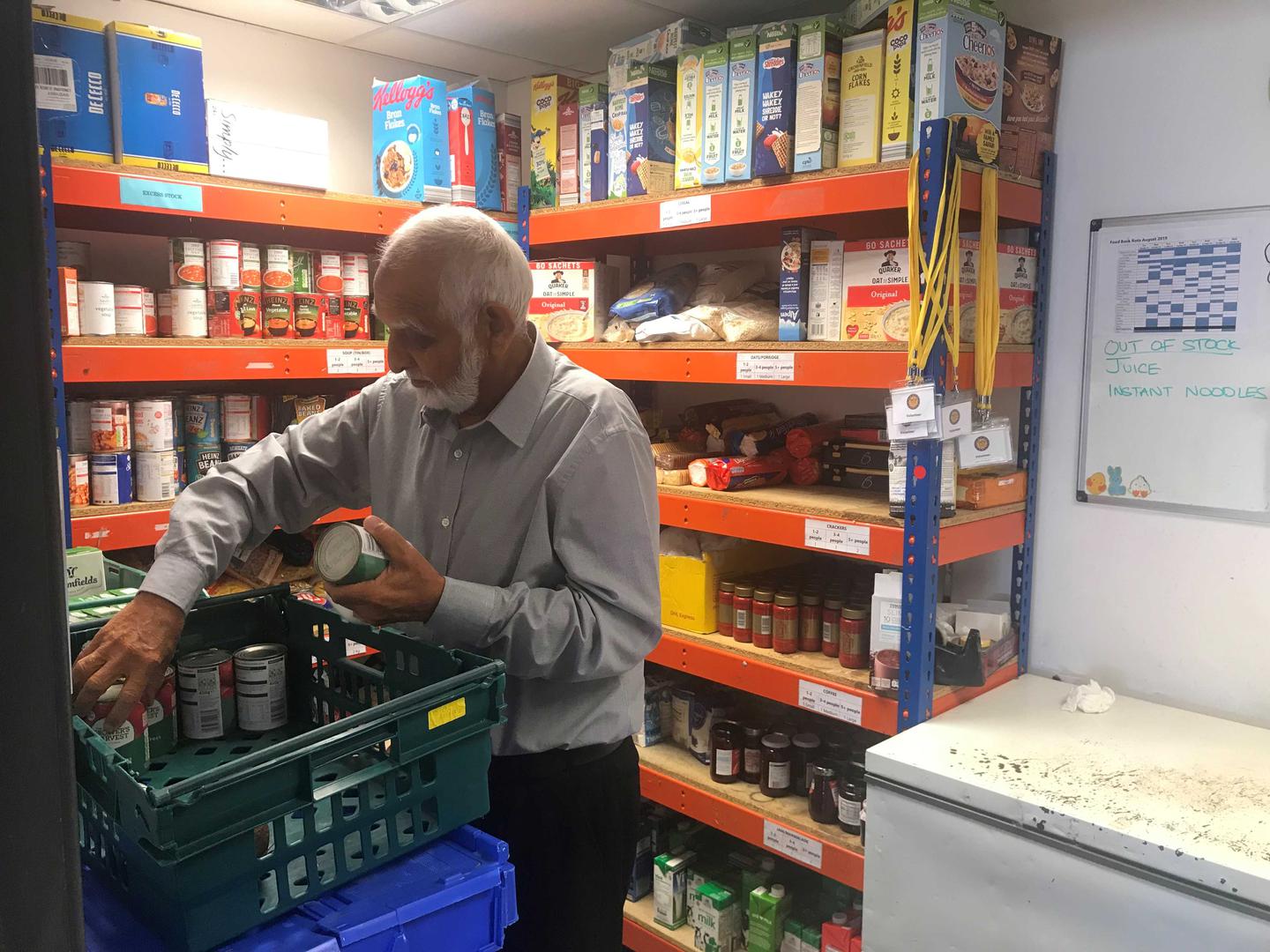 ​عبد الكريم سما، المتطوع في "بنك سفرة للغذاء، يعرّب بعض الأطعمة المعلّبة في قسم التخزين في البنك في برنت، شمال غرب لندن، 9 أكتوبر/تشرين الأول 2019. 