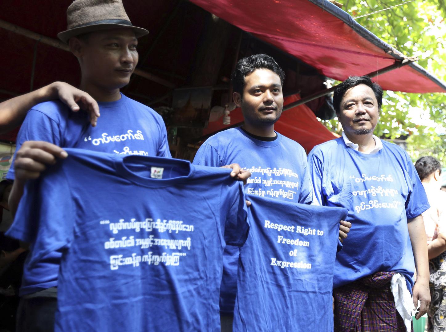 Activists hold blue shirts that read; "Condemning on charge by military oppressing freedom of expression," during the trial of members of the Student Union and leaders of Peacock Generation "Thangyat" Performance Group, Wednesday, Oct. 30, 2019, in Yangon