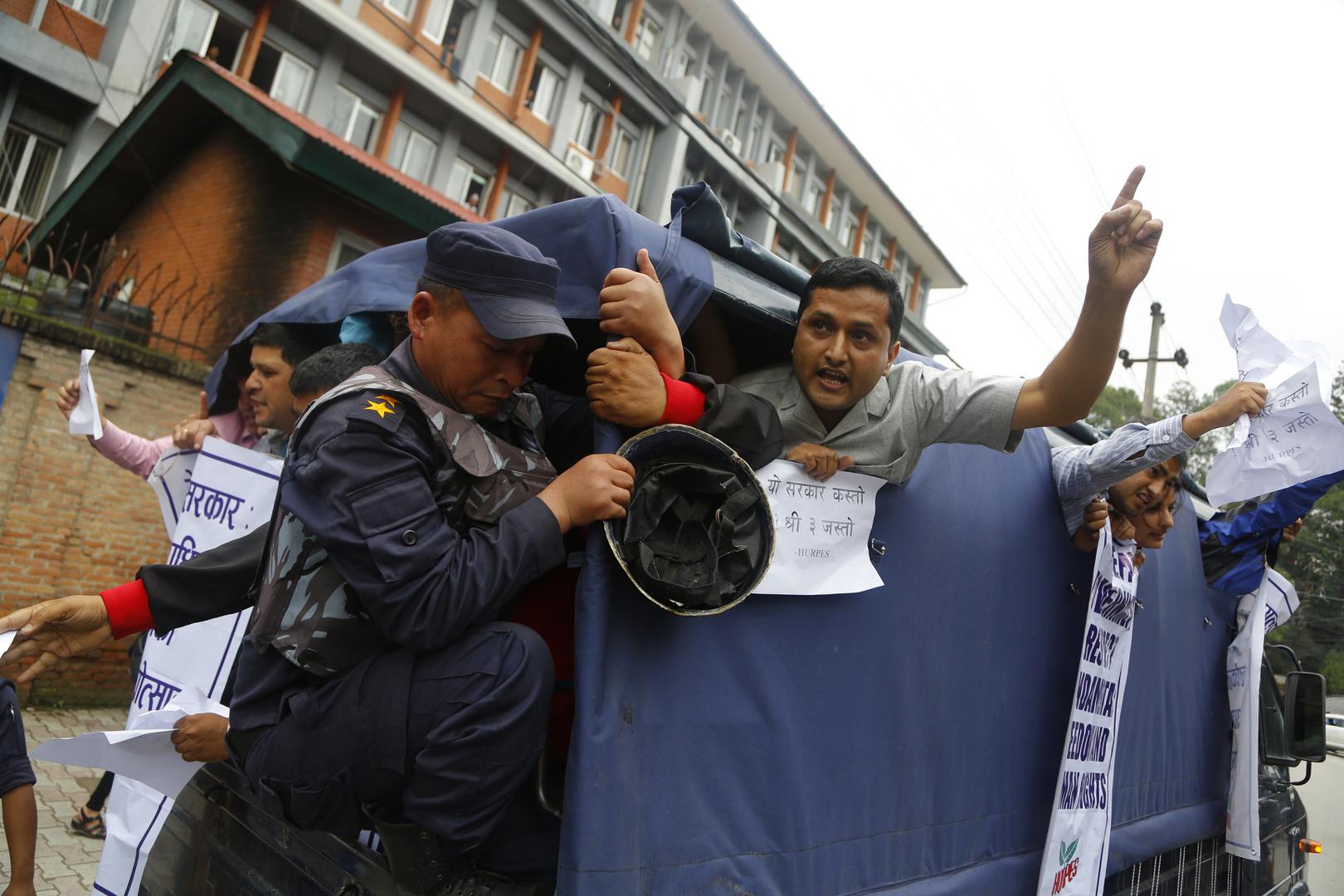 Nepalese activists shout slogans after being detained by police during a protest against the government, in front of the prime minister's office in Kathmandu, Nepal, Tuesday, July 10, 2018. 