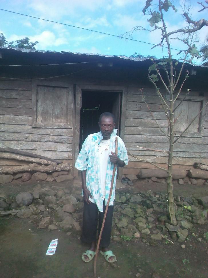 Cusmas tient un bâton de bois qui l’aide à se déplacer dans le village de Mautu, région du Sud-Ouest. 