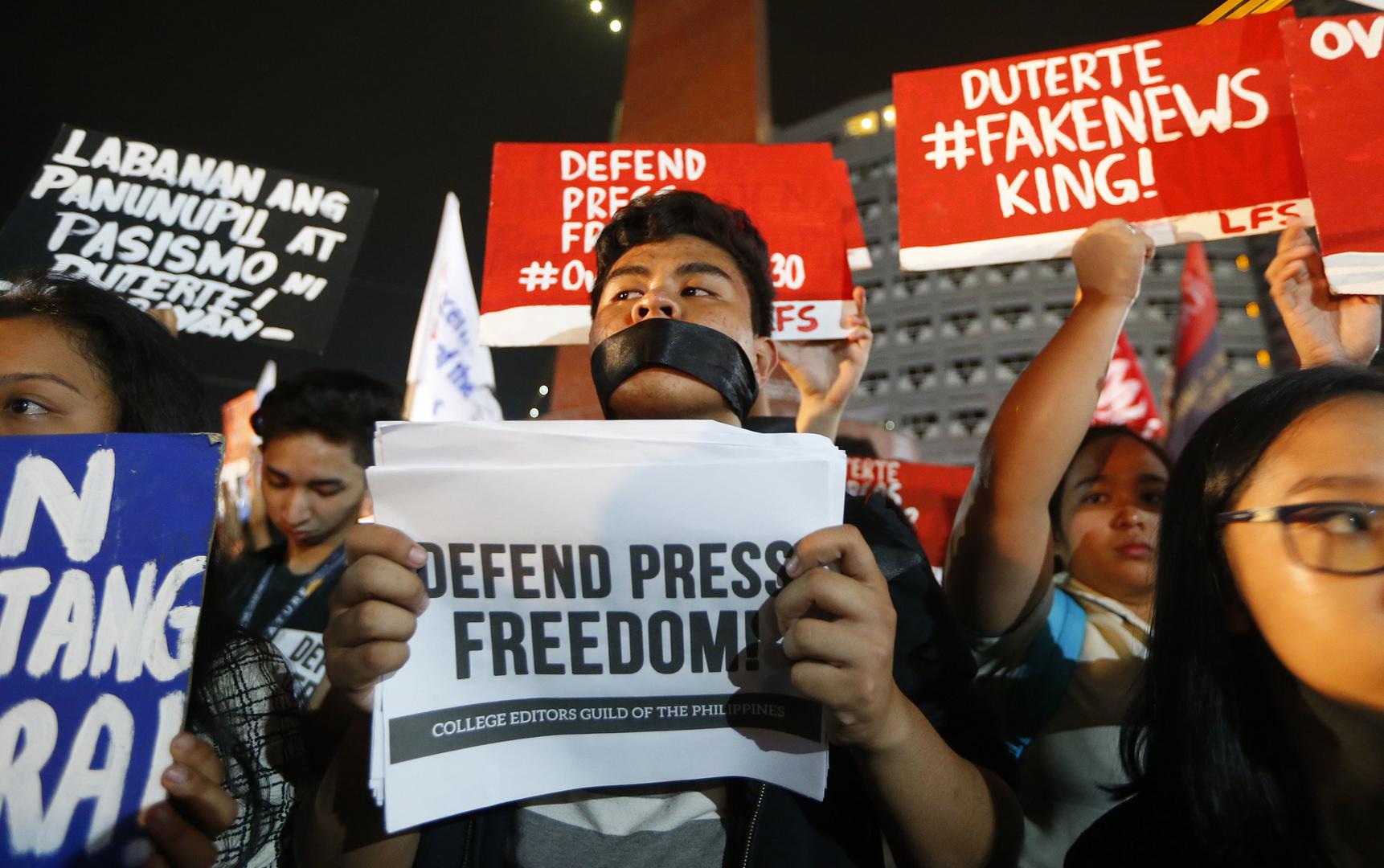 Journalists and supporters, wearing black, display their messages during a protest against the recent Securities and Exchange Commission's revocation of the registration of Rappler, an online news outfit, Friday, Jan. 19, 2018, northeast of Manila, Philip