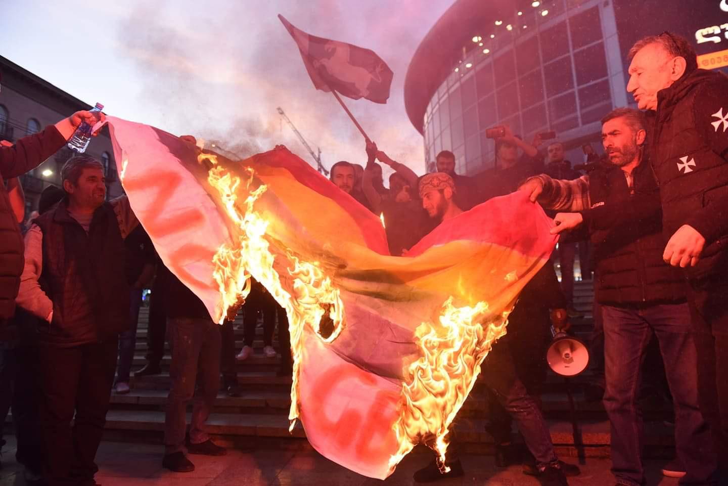 Demonstrators in Tbilisi burn an LGBT flag before the screening of the film And Then We Danced.