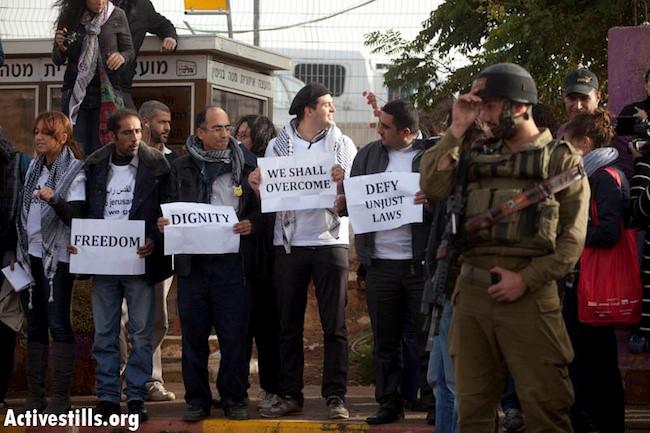 Activistas palestinos esperan a subir a un autobús israelí que conecta un asentamiento israelí en Cisjordania con la Jerusalén Oriental ocupada, para protestar contra las restricciones discriminatorias de movimiento, el 15 de noviembre de 2011.