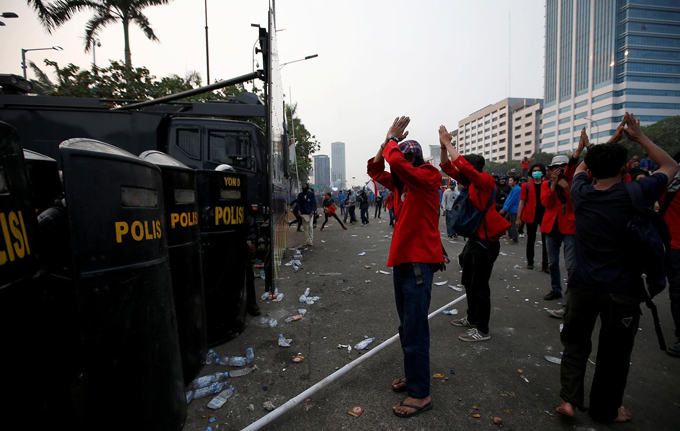 University students gesture in front of police officers during a protest against the draft criminal code in Jakarta, Indonesia, September 24, 2019.