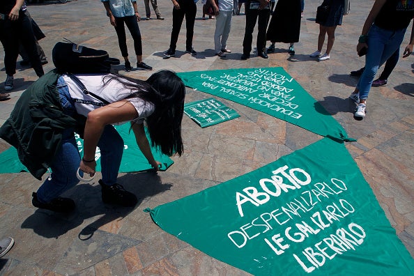 Women organize green cloth banners to be placed on sculptures of Colombian artist Fernando Botero during a protest in Medellin, Colombia on September 28, 2019.
