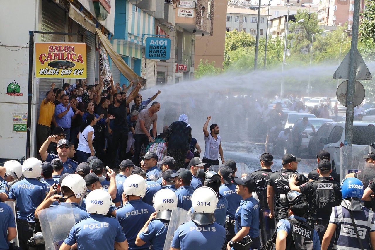 Police use water cannons and tear gas to disperse crowds protesting removal of elected mayors in Diyarbakır. 