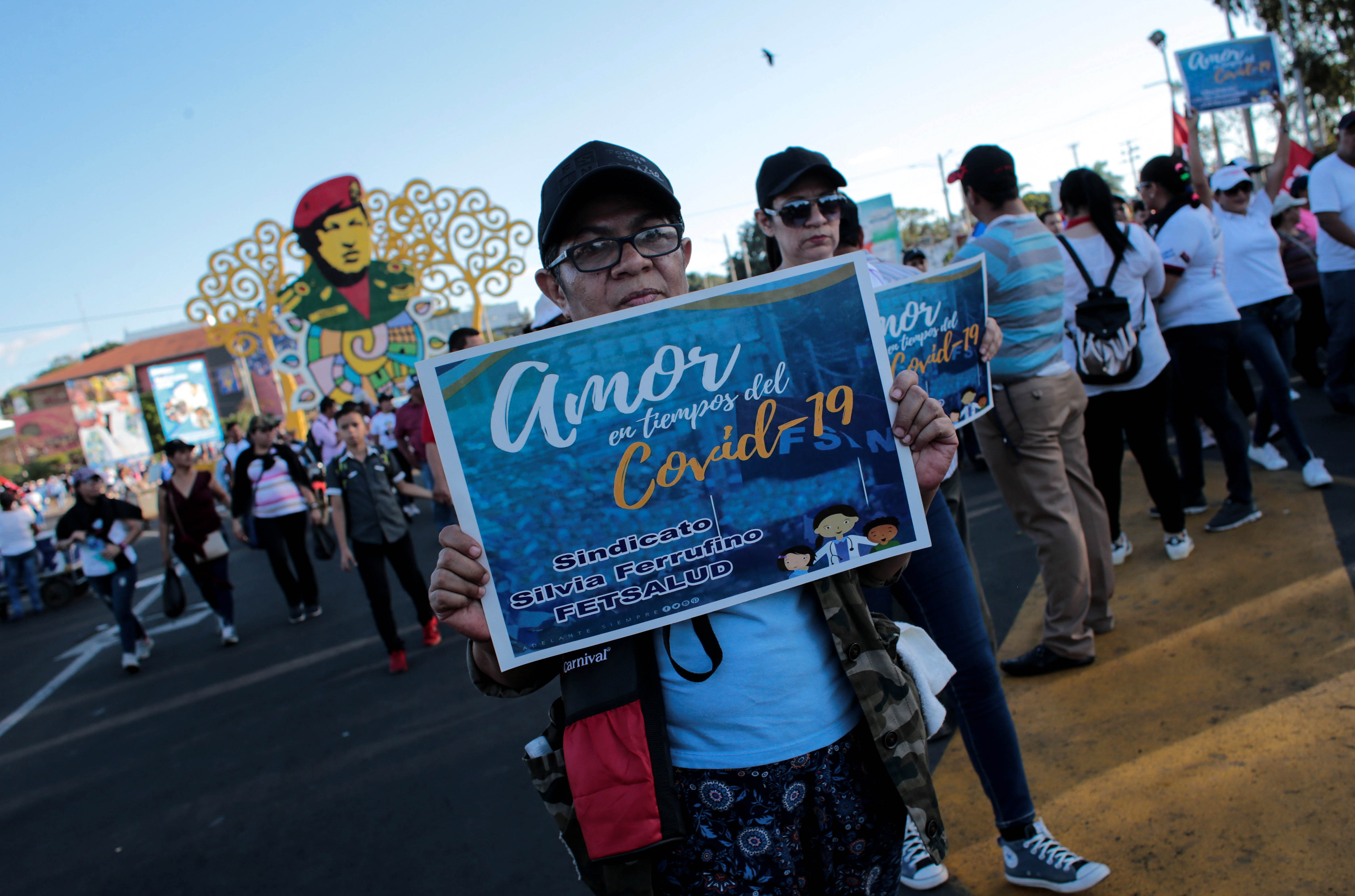 A woman holds a sign that reads "Love in Times of Covid-19" during a government-sponsored march in Managua, Nicaragua, on March 14, 2020.