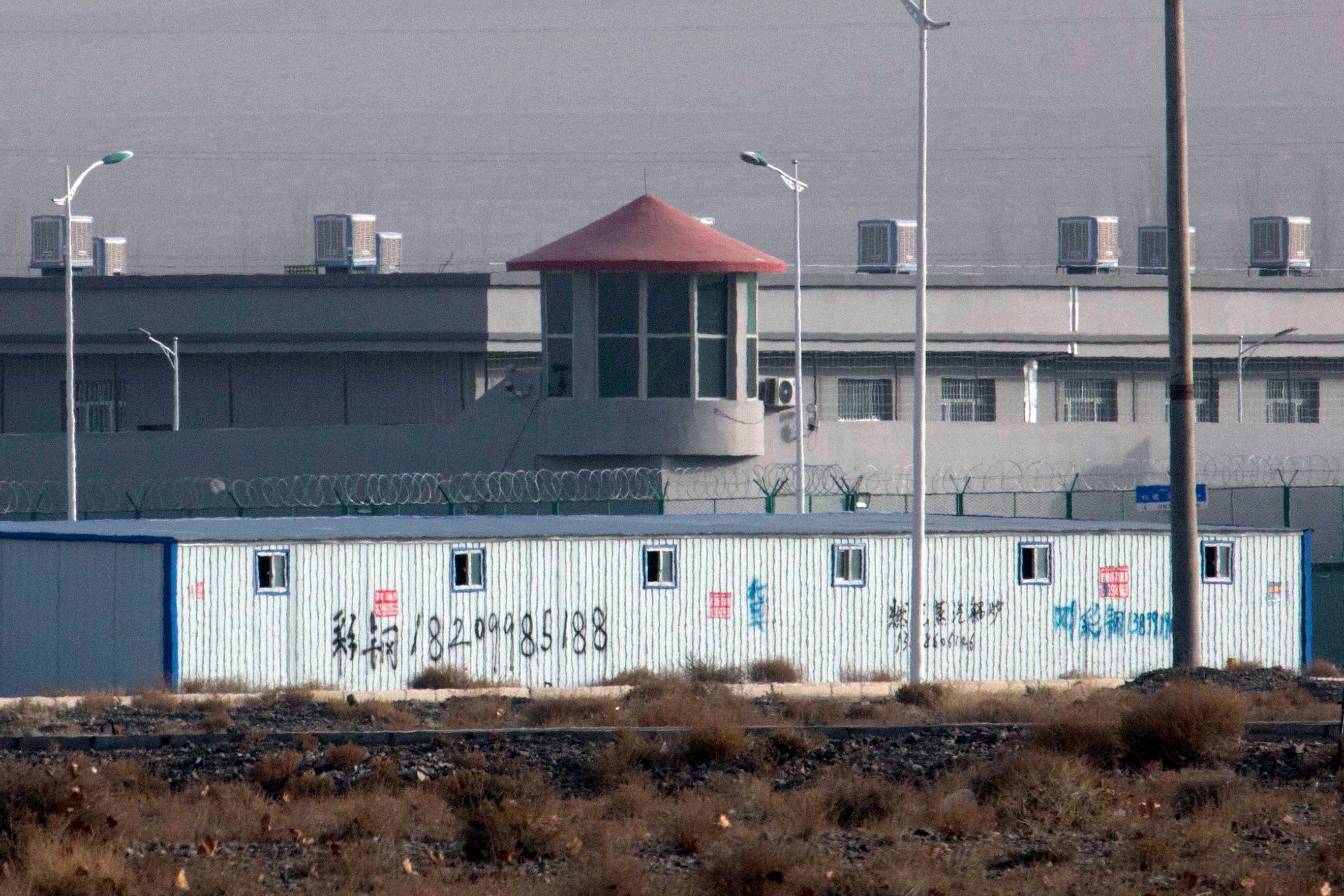 In this Monday, Dec. 3, 2018, file photo, a guard tower and barbed wire fences are seen around a facility in the Kunshan Industrial Park in Artux in western China's Xinjiang region. China has responded with swift condemnation on Wednesday, Dec. 4, 2019, a