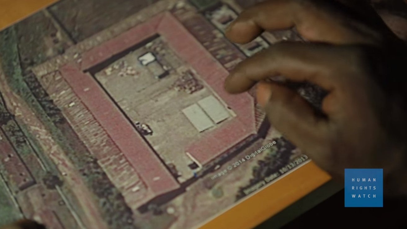 A former Gikondo detainee uses a satellite image of the transit center to indicate which rooms were used for different categories of detainees, when he was there. 