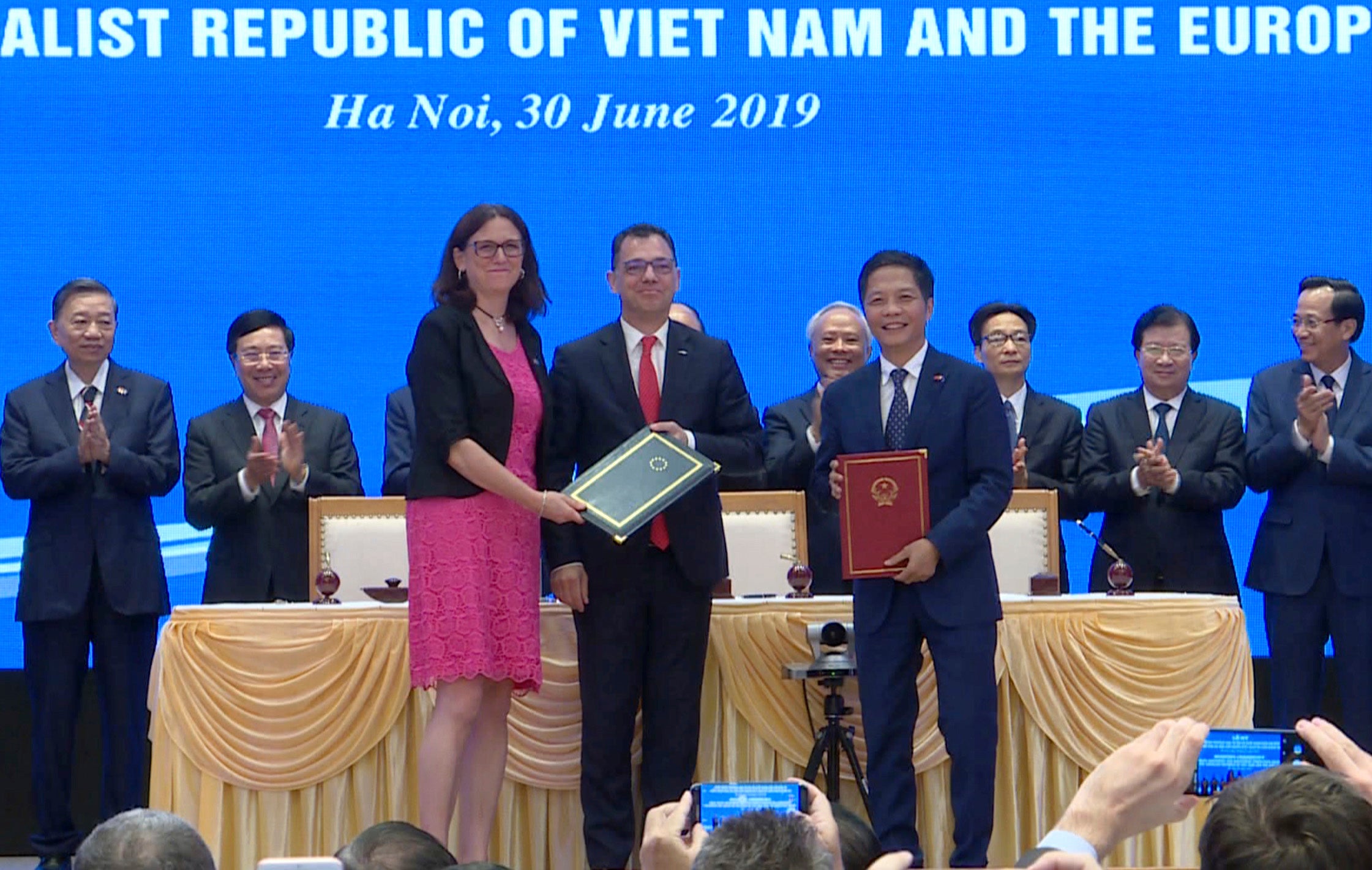 EU Commissioner for Trade Cecilia Malmstrom, front left, and Vietnamese Trade Minister Tran Tuan Anh, front right, stand together as they exchange documents aftering signing a free trade agreement in Hanoi, June 30, 2019. 