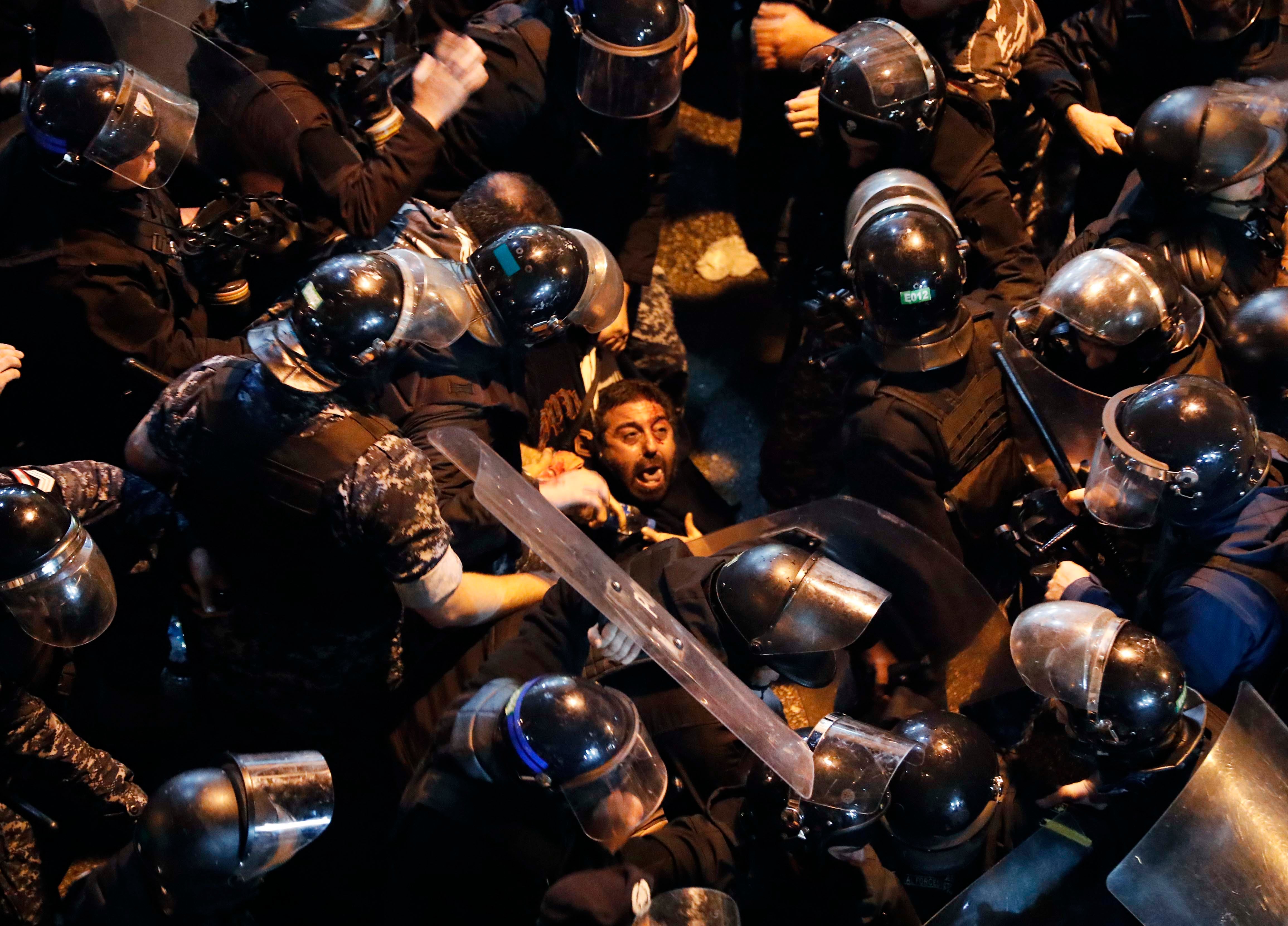 قوات مكافحة الشغب تعتقل متظاهرا أمام "ثكنة الحلو" في بيروت، لبنان، 15 يناير/كانون الثاني 2020. 
