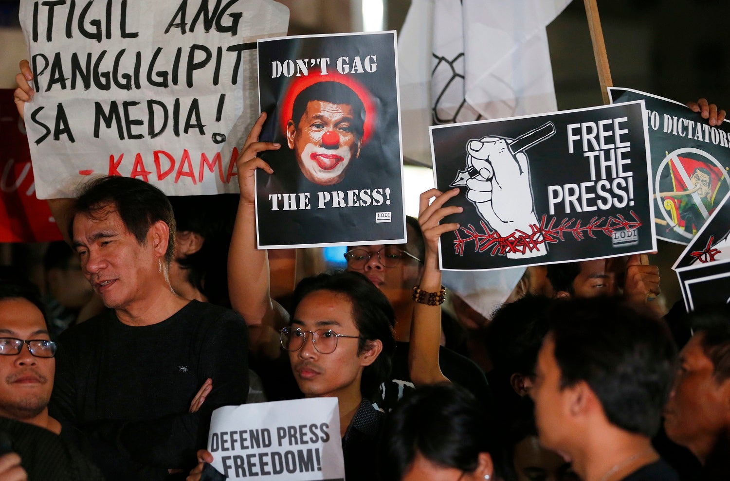 Journalists and supporters, wearing black, display their messages during a protest against the recent Securities and Exchange Commission's revocation of the registration of Rappler, an online news outfit, Friday, Jan. 19, 2018, northeast of Manila, Philip
