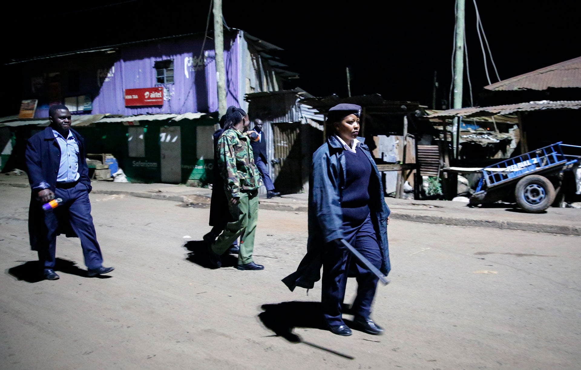 Kenyan police carrying batons and teargas patrol looking for people out after curfew in the Kibera slum, or informal settlement, of Nairobi, Kenya, March 29, 2020.