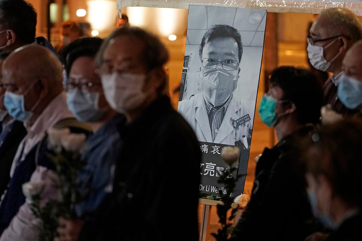 People wearing masks, attend a vigil for Chinese doctor Li Wenliang, in Hong Kong, February 7, 2020.