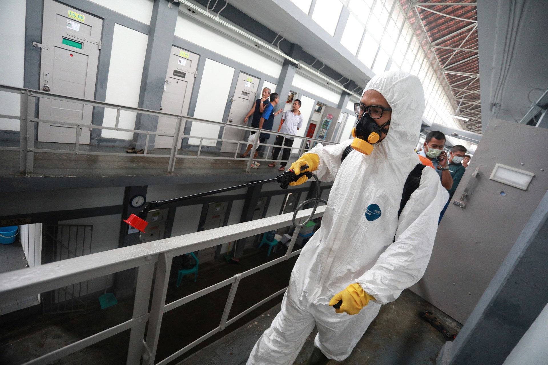 An Indonesian Red Cross worker wearing a protective suit sprays disinfectant at a prison in Bandung, West Java, Indonesia, March 23, 2020.