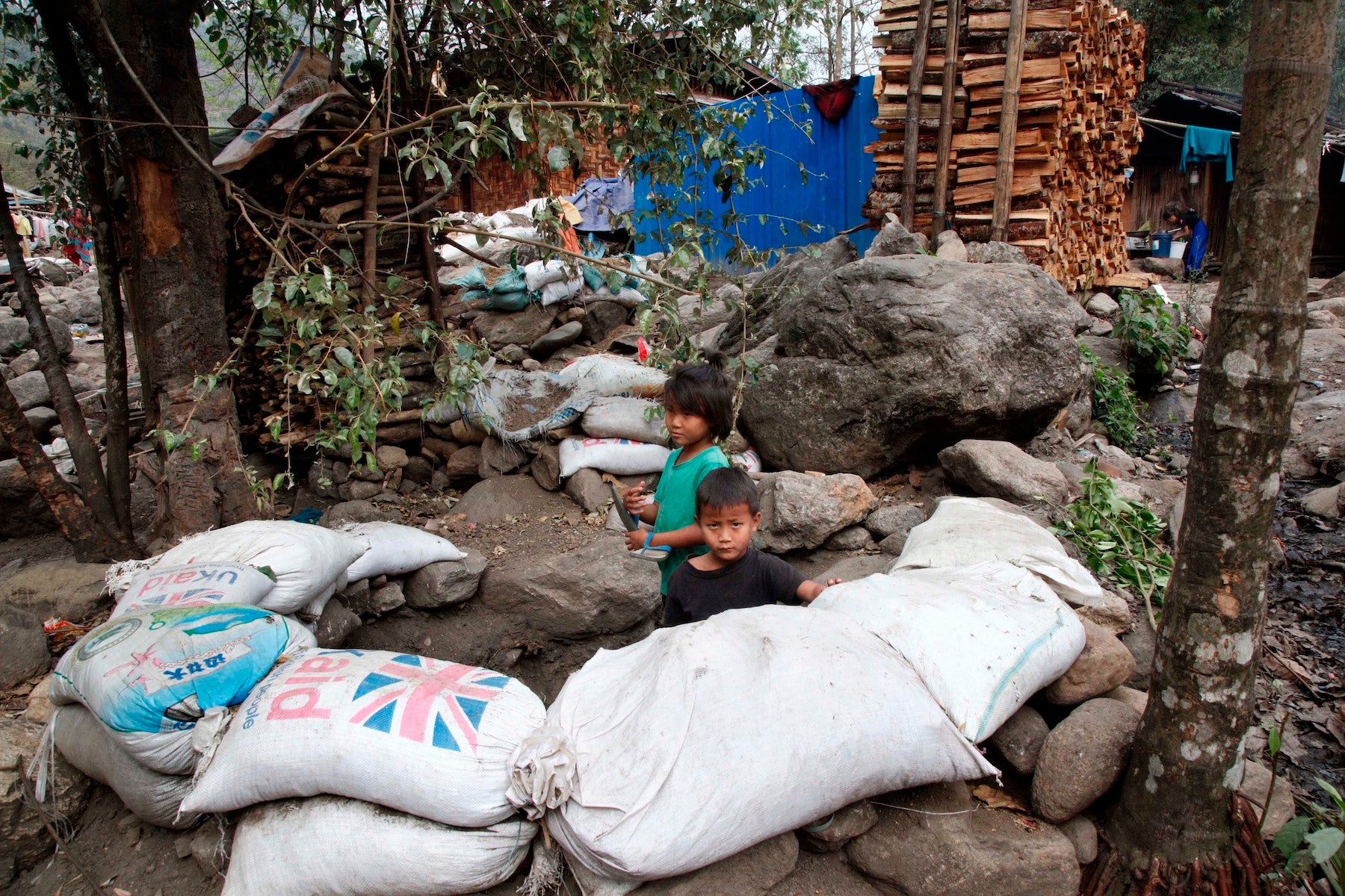 Children play in a makeshift bomb-shelter made with sandbags at Woi Chyai IDP camp, Kachin State, Myanmar.