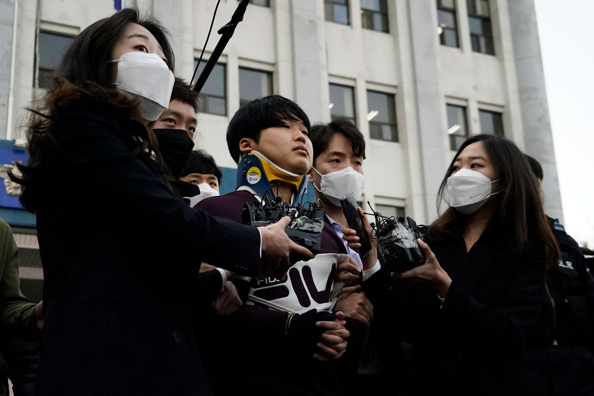 Cho Ju-bin, center, leader of South Korea's online sexual blackmail ring called "Nth room," is surrounded by journalists while walking out of a police station as he is transferred to prosecutors' office for further investigation in Seoul, South Korea