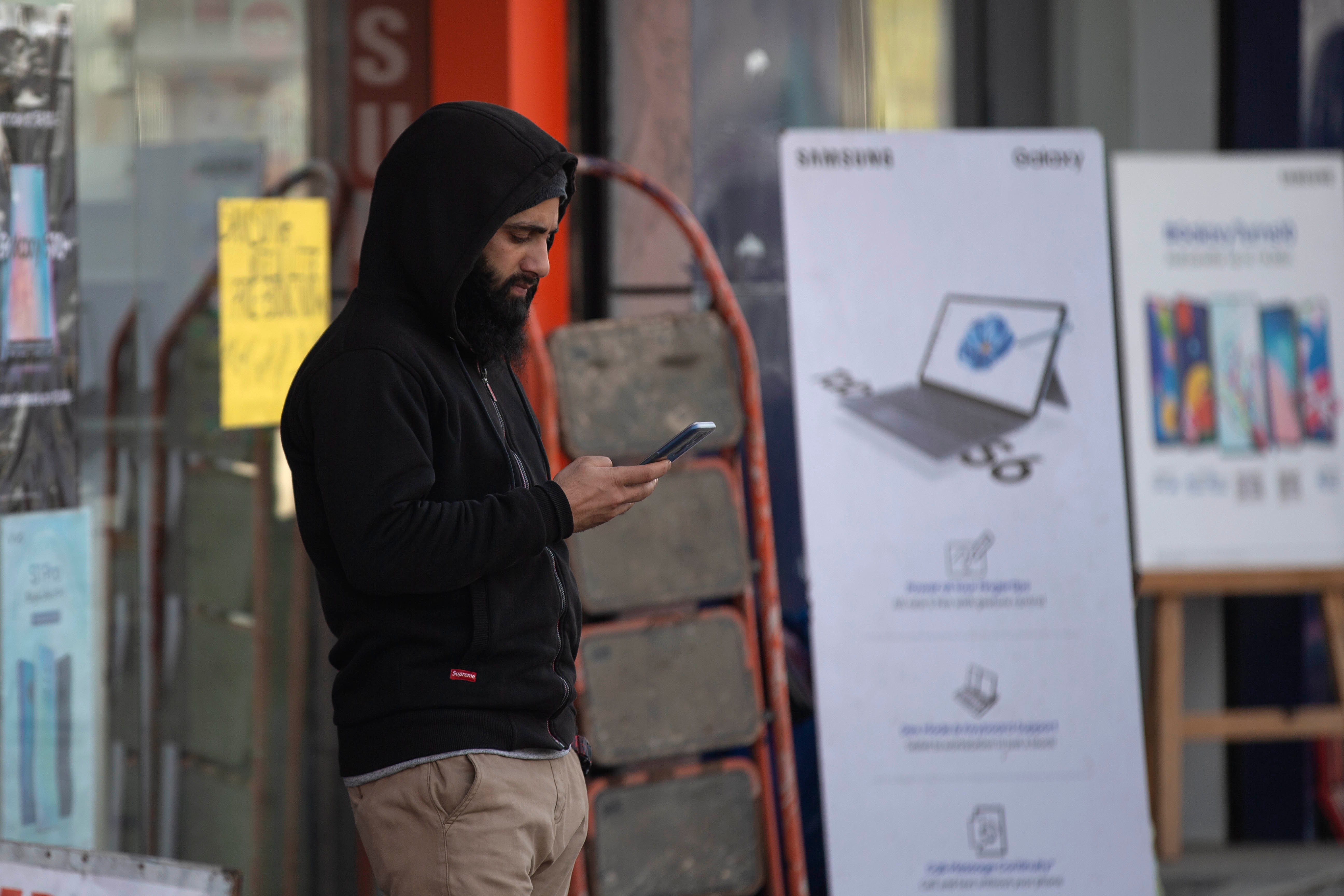 Un homme regarde son téléphone portable à Srinagar, dans le territoire du Cachemire contrôlé par l'Inde, le 30 janvier 2020. 