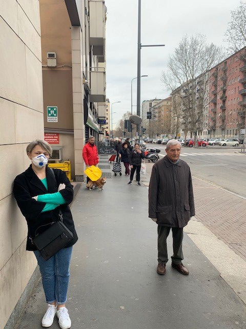 People standing one meter apart while on line outside a supermarket in Milan, March 12, 2020.