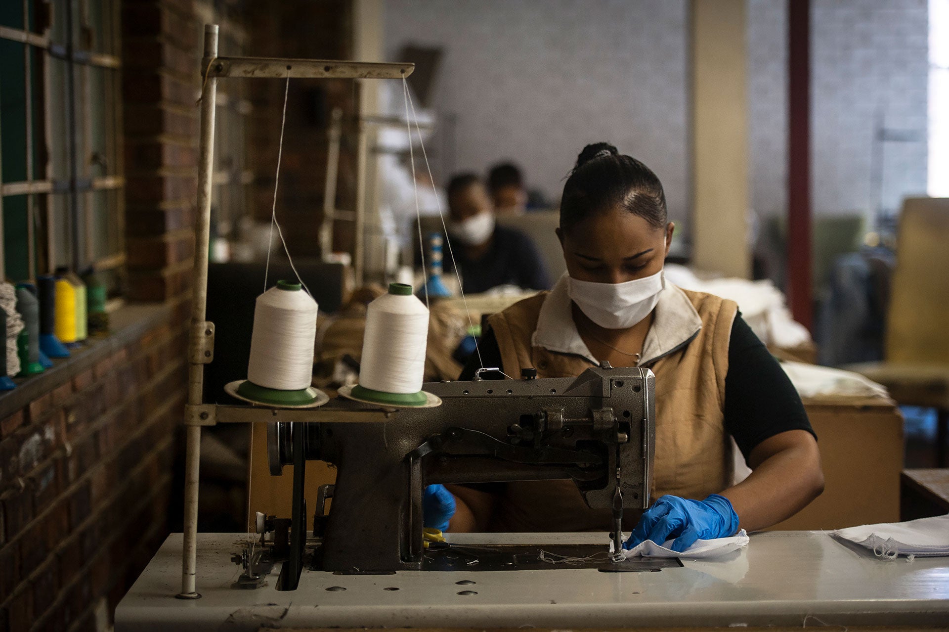 A woman sews face masks at a furniture factory in Eldorado Park, Johannesburg, Tuesday, March 24, 2020,