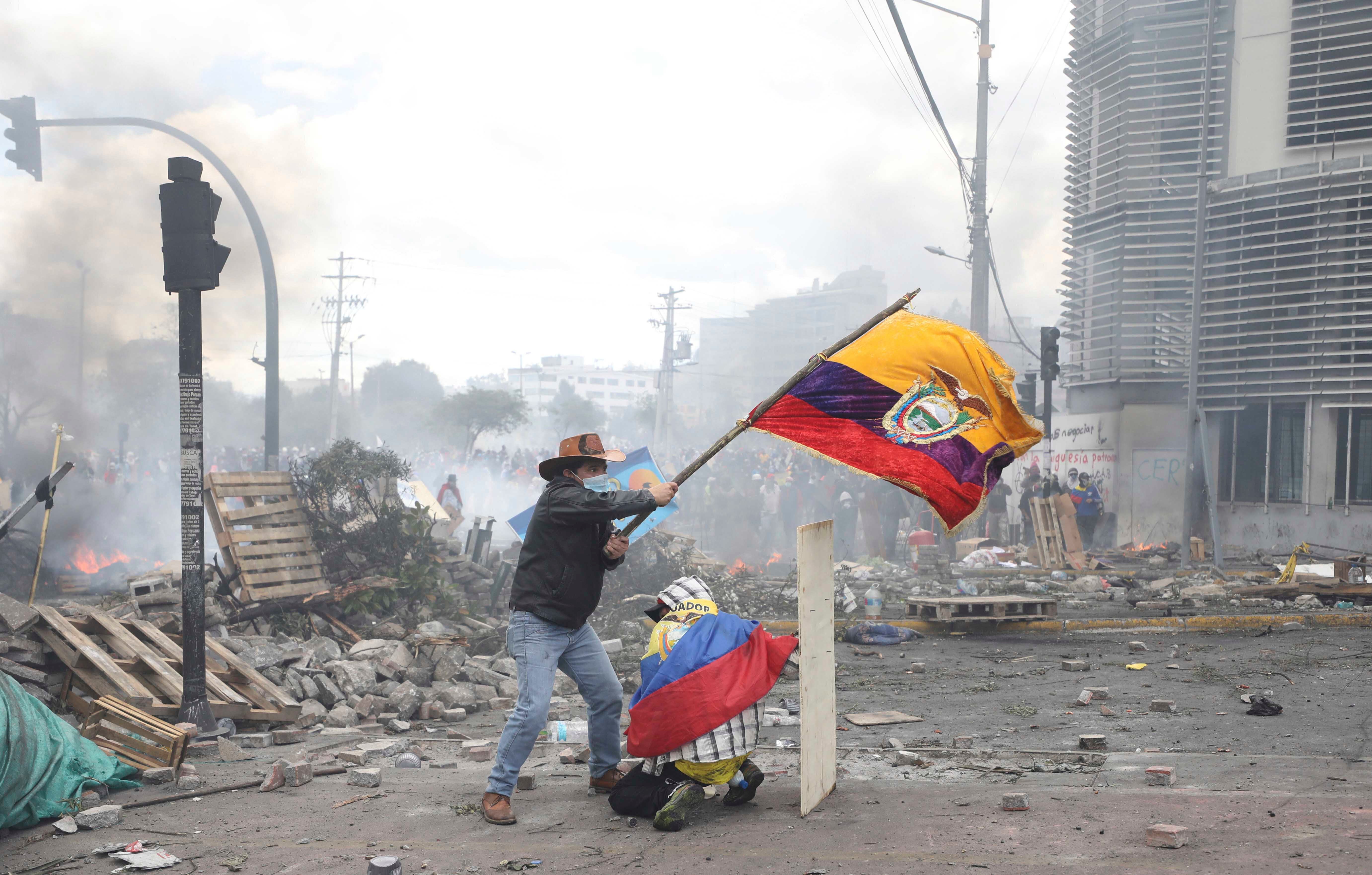 An anti-government demonstrator on Oct. 12, 2019 in Quito, Ecuador, waves the national flag during sometimes violent protests which began when President Lenin Moreno's decision to cut subsidies led to a sharp increase in fuel prices. 