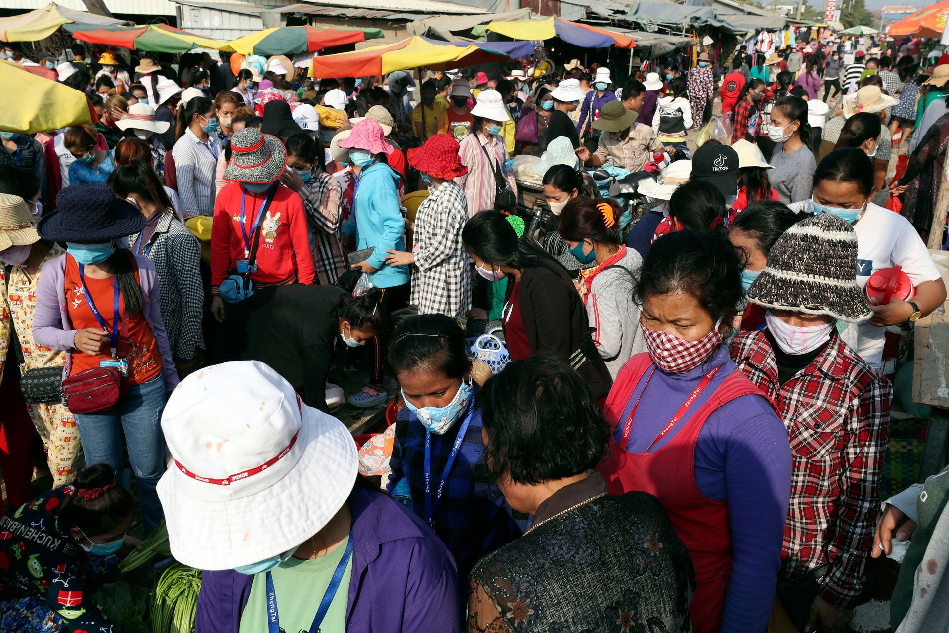 2020년 3월 20일, 캄보디아 프놈펜 인근에서 의류공장 노동자들이 일을 마친 후 마스크를 쓰고 걸어나오고 있다. © 2020 AP 사진/헹 시니스