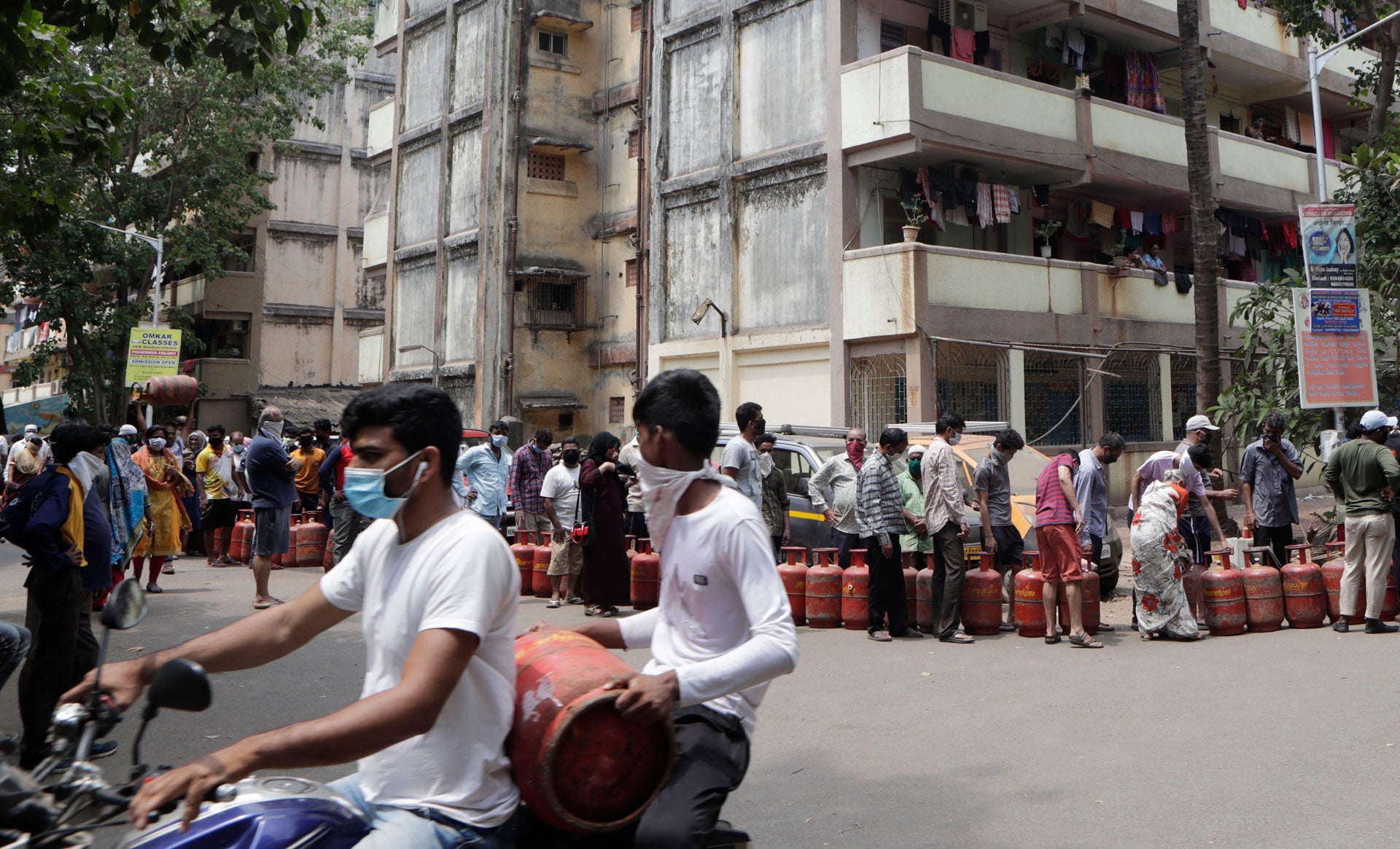 People stand in a queue to get their refills of cooking gas cylinders in Mumbai, India, March 26, 2020.