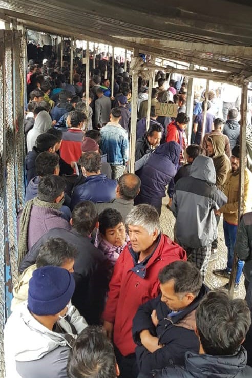 طالبو لجوء ومهاجرون ينتظرون في طابور الطعام في مخيم موريا في جزيرة ليسبوس اليونانية في أوائل نيسان 2020. © 2020 خاص