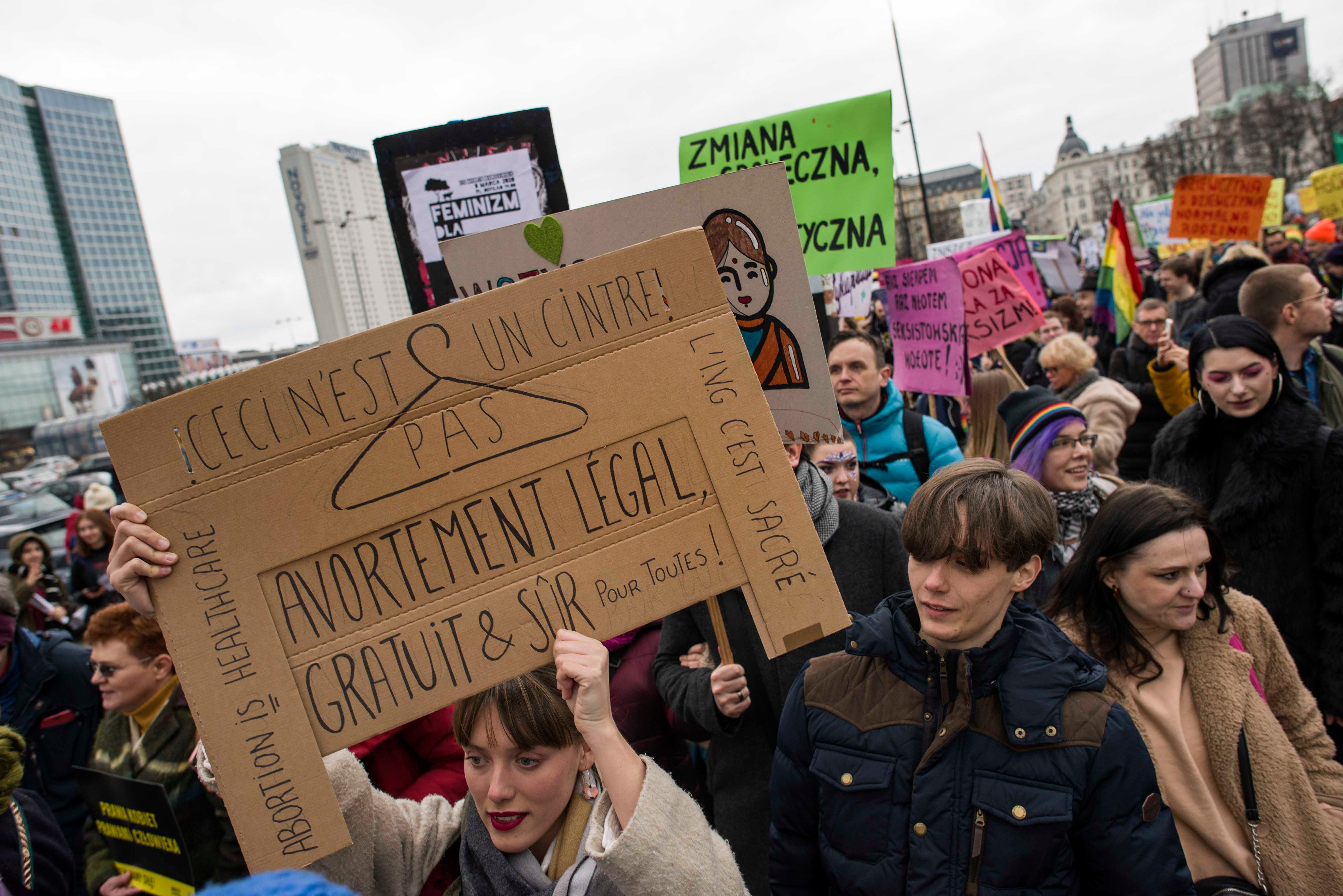 Une jeune femme brandit une pancarte dont le texte est inscrit en français, lors d’une manifestation tenue à Varsovie, en Pologne, le 8 mars 2020 (Journée de la femme), deux jours avant l’interdiction par le gouvernement de rassemblements publics afin d’e