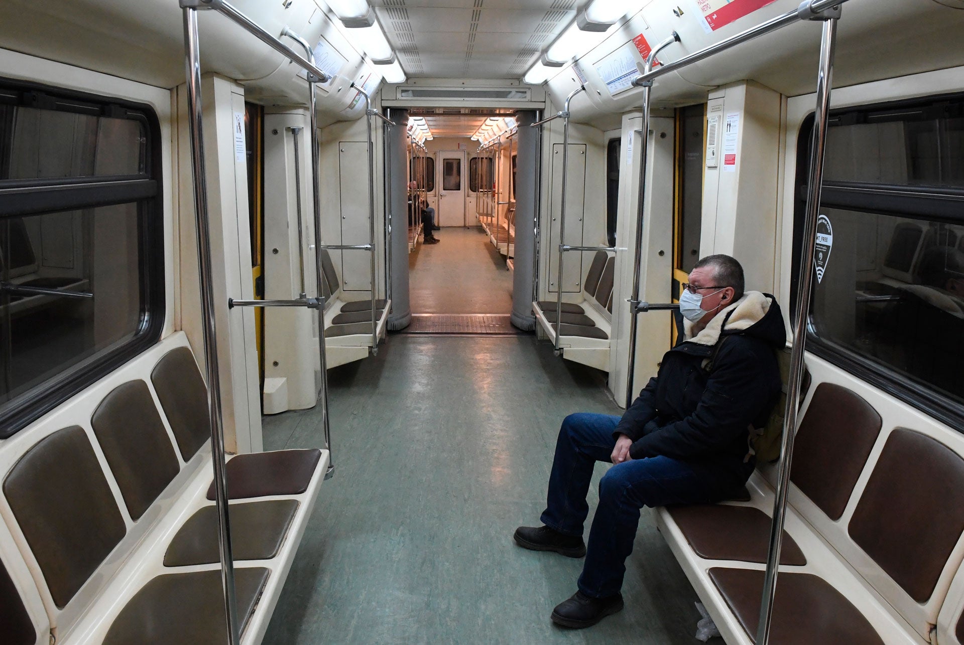 A man wearing a protective face mask rides an empty train on the Moscow Metro, Russia, March 30, 2020.