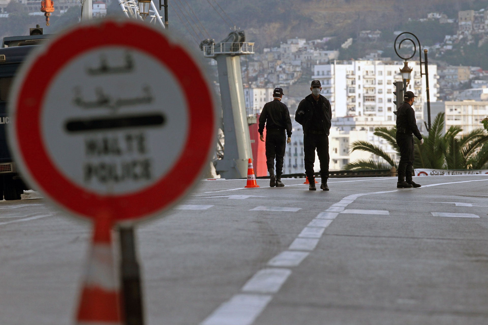 Trois membres des forces de sécurité algériennes, photographiés à Alger, le 8 avril 2020, à un poste de contrôle mis en place pour appliquer un couvre-feu instauré afin d’empêcher la propagation du coronavirus.