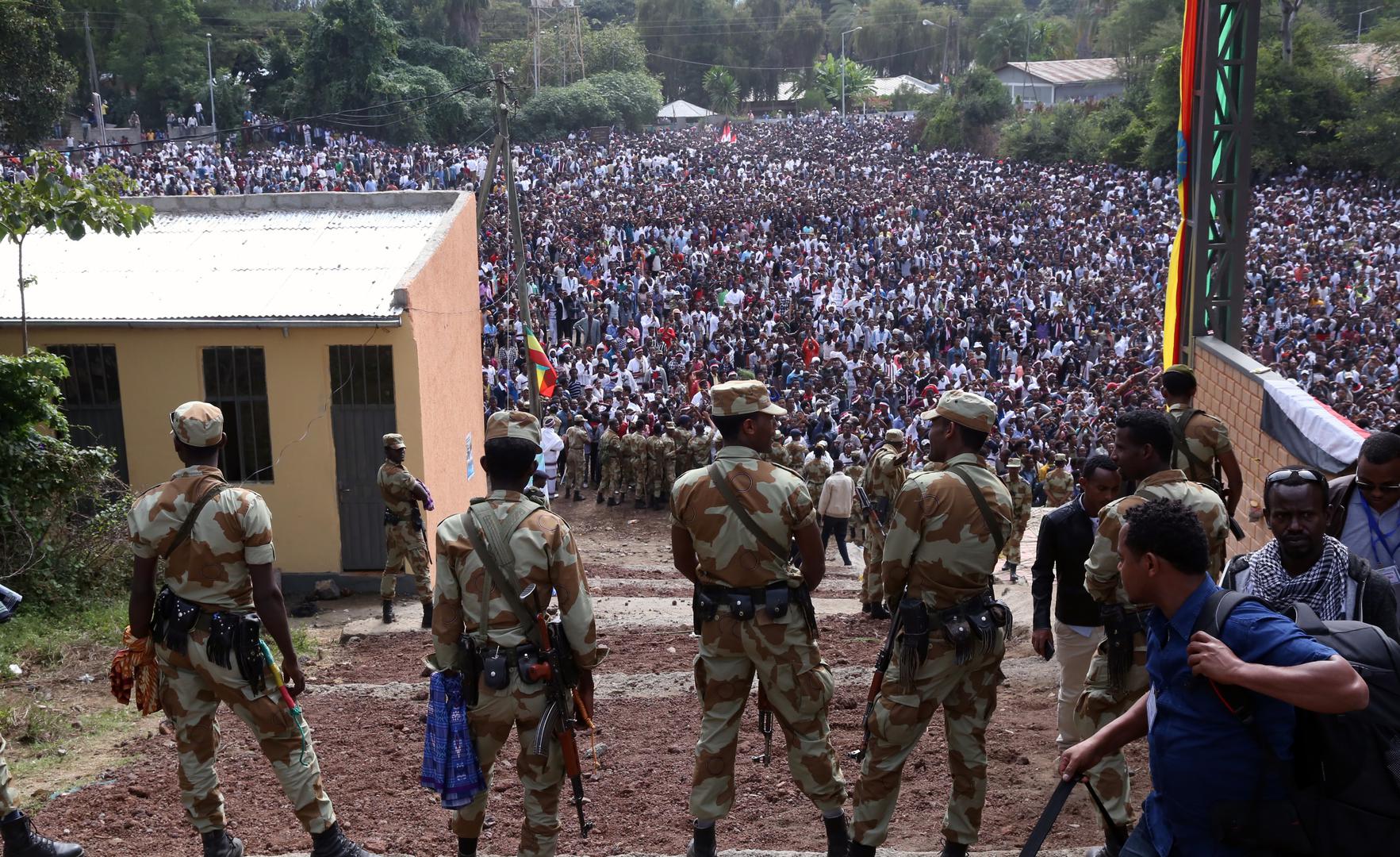 Armed security officials watch as protesters stage a protest against government during the Irreechaa cultural festival in Bishoftu, Ethiopia on October 02, 2016.