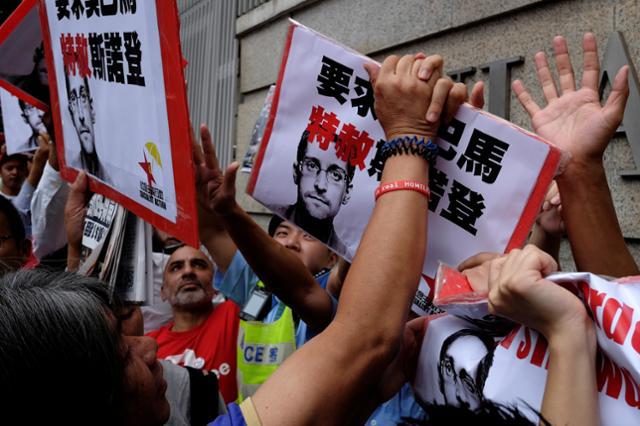 Protesters supporting Edward Snowden confront policemen as they demand that US President Barack Obama grant Snowden a pardon, outside the US Consulate in Hong Kong, China, on September 25, 2016.