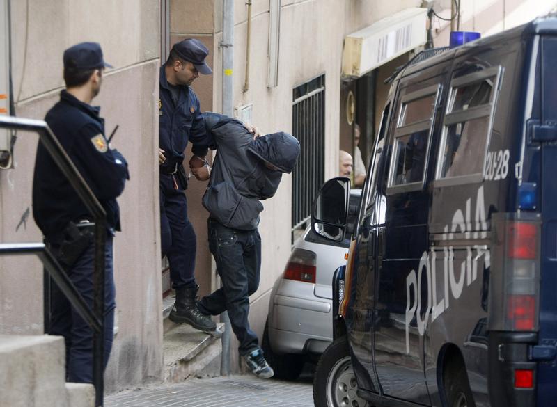 Police escort a suspect who was detained during early morning raids in an operation against a group suspected of financing and recruiting Islamist militants in Santa Coloma de Gramanet, near Barcelona, October 16, 2008.