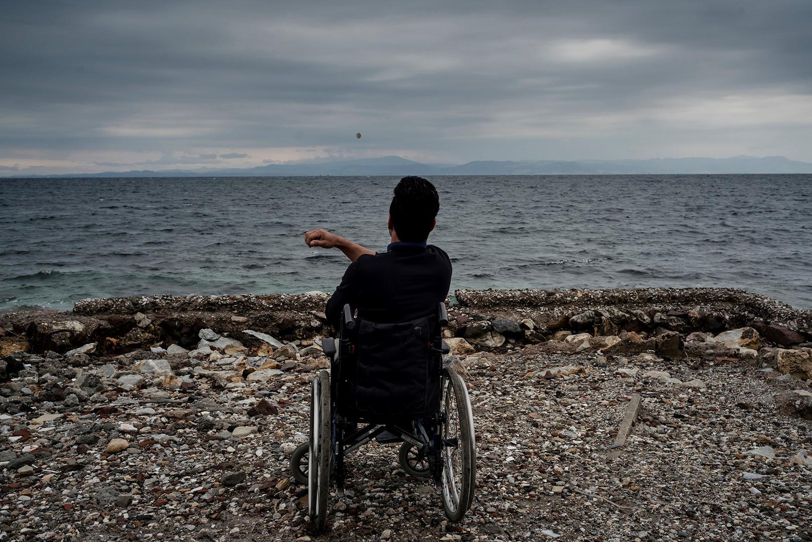 Ali, a 22-year-old Afghan asylum seeker with a disability, living in Moria camp, on the beach in Lesbos, Greece. He told Human Rights Watch he can’t access showers in the camp and sometimes tries to wash himself in the sea. 