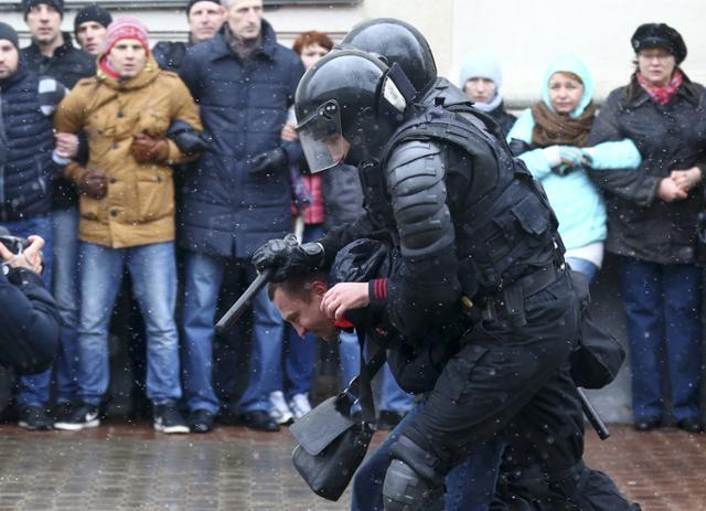 Riot police detain a man during a rally in Minsk on March 25.