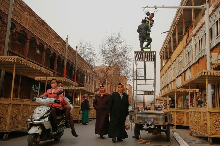 2017年3月23日，工人们在中国新疆维吾尔自治区喀什噶尔购物区安装闭路电视摄像机。国家媒体表示，类似的数千个公安网络措施遍布街头是为了让民众感觉更安全。