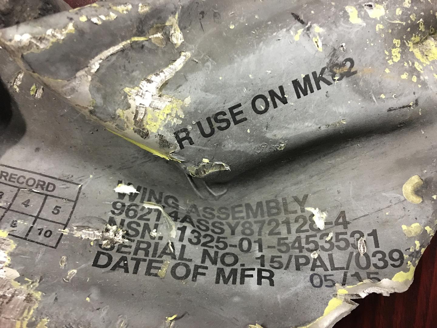 Remnant of a Paveway IV guided bomb that struck the Hodaida warehouses. The national stock number on the wing assembly indicates that Raytheon in the United Kingdom manufactured the bomb in May 2015, after the start of the war.