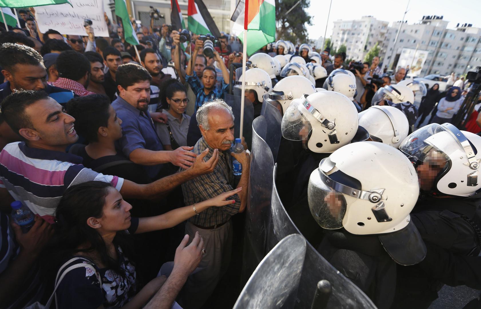 Palestinian riot police confront demonstrators protesting security coordination between the Palestinian Authority (PA) and Israel, in the West Bank city of Ramallah on June 23, 2014.