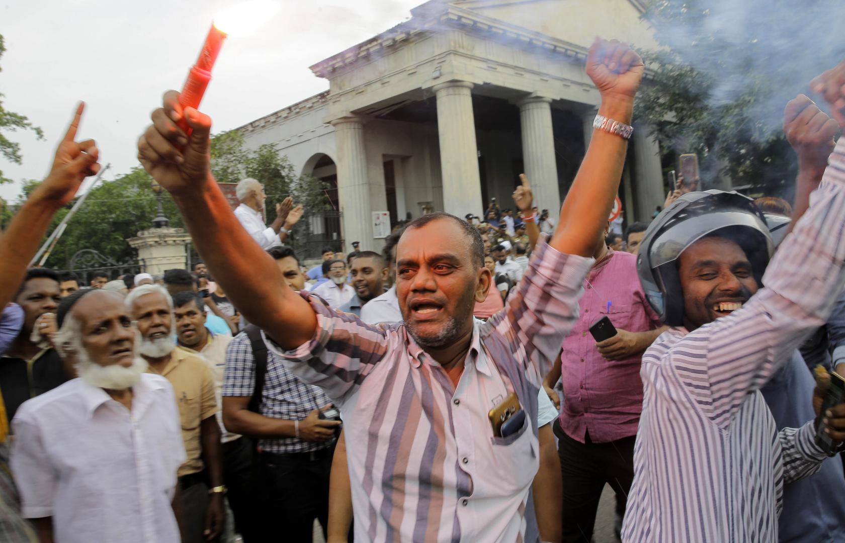 Supporters of ousted Sri Lankan Prime Minister Ranil Wickremesinghe celebrate outside the Supreme Court complex in Colombo after the court unanimously ruled that President Maithripala Sirisena's order to dissolve Parliament was unconstitutional, December 